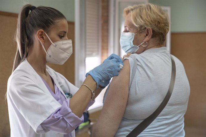 Una enfermera vacuna a una mujer contra la gripe y el Covid.