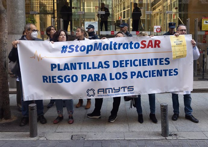 Varias personas con una pancarta en la que se lee: '#StopmaltratoSAR', participan en una concentración enmarcada en el inicio del modelo de atención urgente extrahospitalaria, frente a la consejería de Sanidad