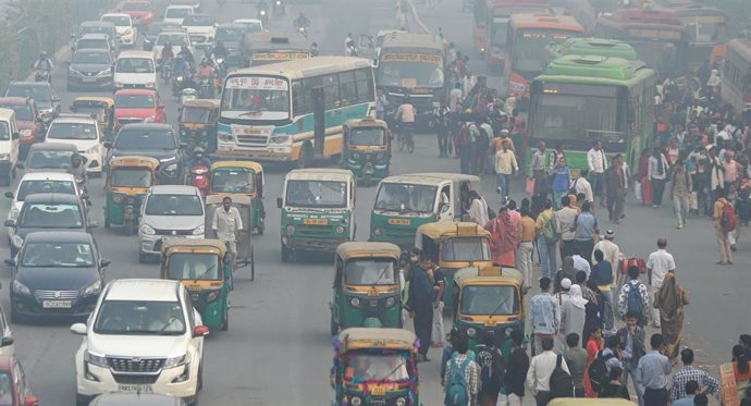 Vehículos y personas en una calle de Nueva Delhi, India
