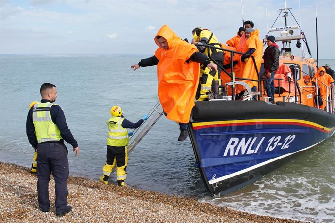 12 October 2022, United Kingdom, Dover: A group of people thought to be migrants are brought in to Dungeness beach by the Dungeness lifeboat following a small boat incident in the English Channel. Photo: Gareth Fuller/PA Wire/dpa