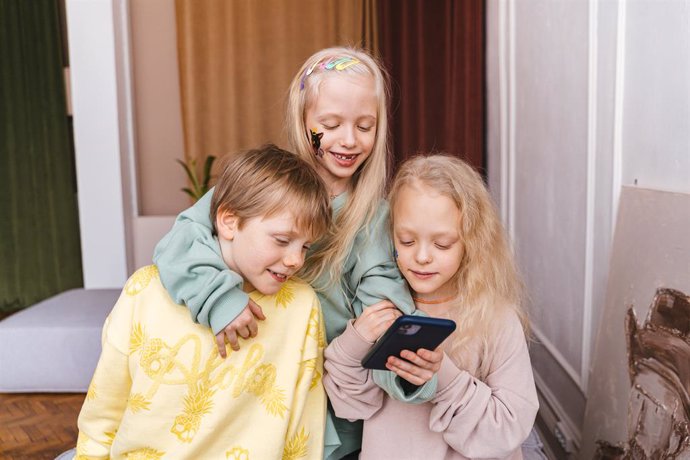Niños utilizando un móvil.