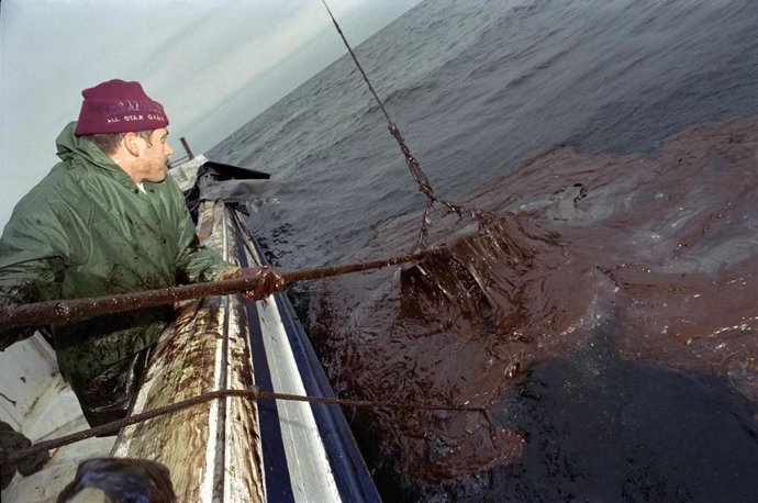 Archivo -  Un barco pesquero de cerco retirando restos del fuel tras el Prestige