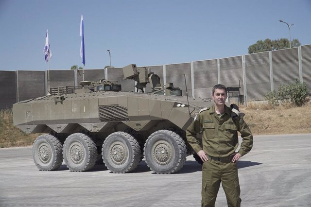 Archivo - Un soldado israelí junto a un vehículo blindado de transporte de tropas