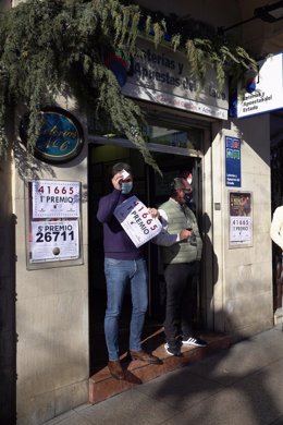 Archivo - Un empleado de la administración Carmen situada en la calle Muro del Carmen sostiene el cartel del número 41665 correspondiente al 'Gordo' del Sorteo Extraordinario de la Lotería del Niño, a 6 de enero de 2021, en Logroño, La Rioja, (España). El
