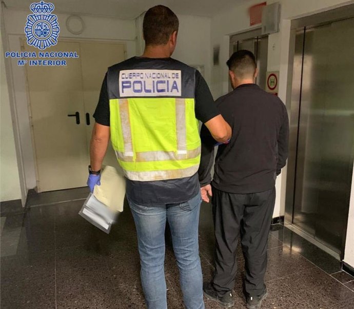 Un agente de la Policía Nacional escolta al detenido por tráfico de drogas en el desmantelamiento de un punto de venta en Palma