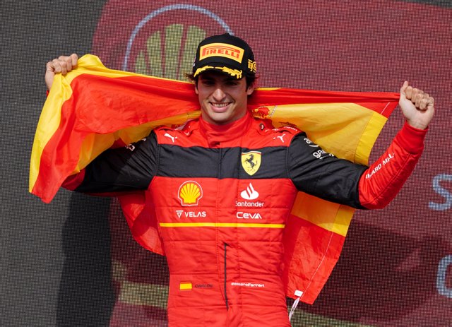 03 July 2022, United Kingdom, Towcester: First-placed Spanish F1 driver Carlos Sainz Jr. of team Ferrari celebrates on the podium after the British Grand Prix 2022 at Silverstone Circuit. Photo: David Davies/PA Wire/dpa