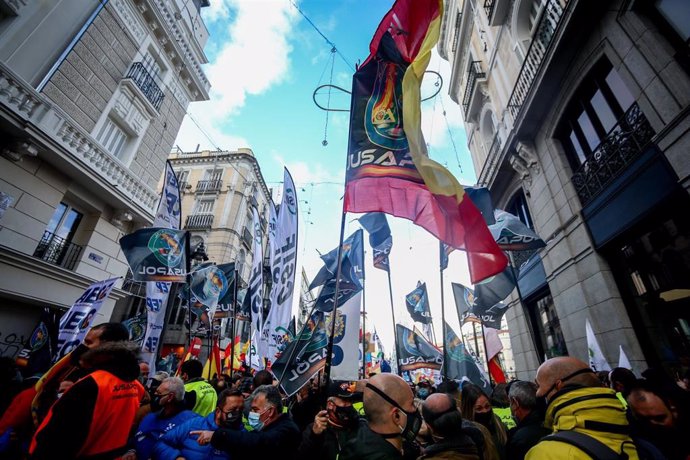 Archivo - Varias personas sostienen banderas de España en una manifestación convocada por Jusapol contra la 'ley mordaza'
