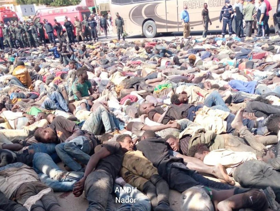 Archivo - Inmigrantes subsaharianos amontonados tras los enfrentamientos con la Policía de Marruecos durante un intento de salto de la valla de Melilla