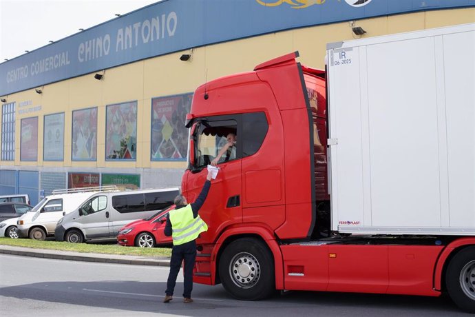 Archivo - Un hombre entrega un papel a un transportista durante la convocatoria de paros en el transporte del pasado mes de marzo