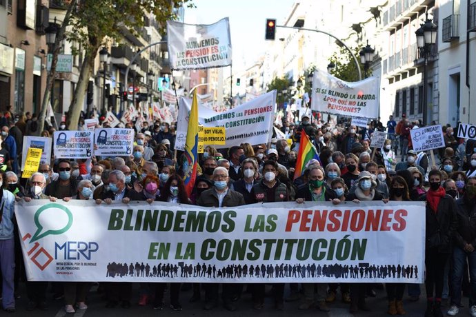 Archivo - Un grupo de personas con pancartas durante una manifestación que reclama el blindaje de las pensiones en la Constitución
