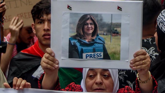 Archivo - Una mujer con la fotografía de la periodista palestino-estadounidense Shirín abu Aklé.