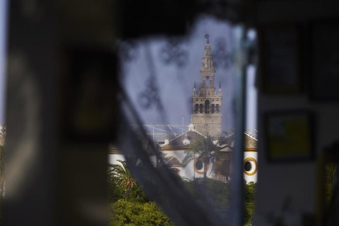 Archivo - Detalle de la Giralda entre las cortinas de una caseta de la Velá de Santiago y Santa Ana 2022 en el barrio de Triana, a 22 de julio de 2022 en Sevilla (Andalucía, España)
