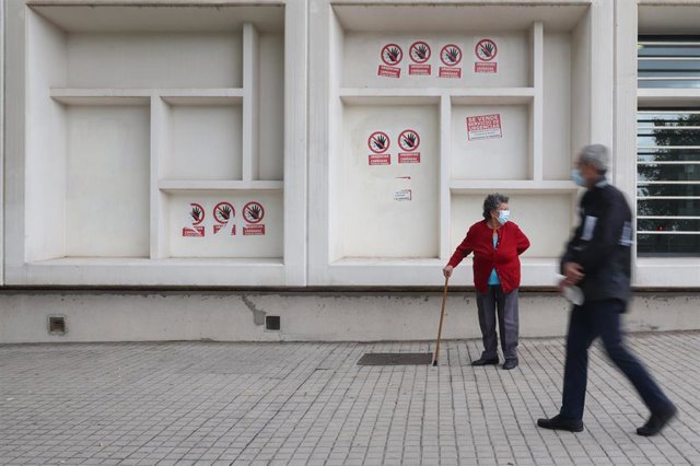 Dos personas mayores con mascarilla delante del Centro de Salud Pavones