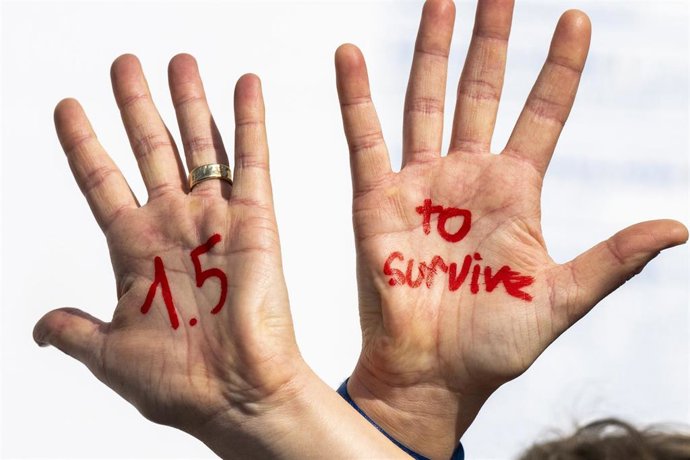 16 November 2022, Egypt, Sharm El-Sheikh: A participant with "1.5 to survive" painted on her hands with red paint during a protest for the 1.5 degree target by doctors and medical students from several countries during the 2022 United Nations Climate Ch