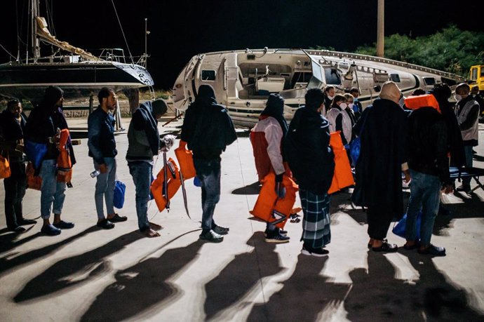 16 November 2022, Italy, Roccella Ionica: Migrants walk to the first aid camp upon their arrival in Roccella's port. 28 migrants, mainly from Bangladesh, have been rescued on a boat in distress nearly 115 nautical miles from the coast and carried to the