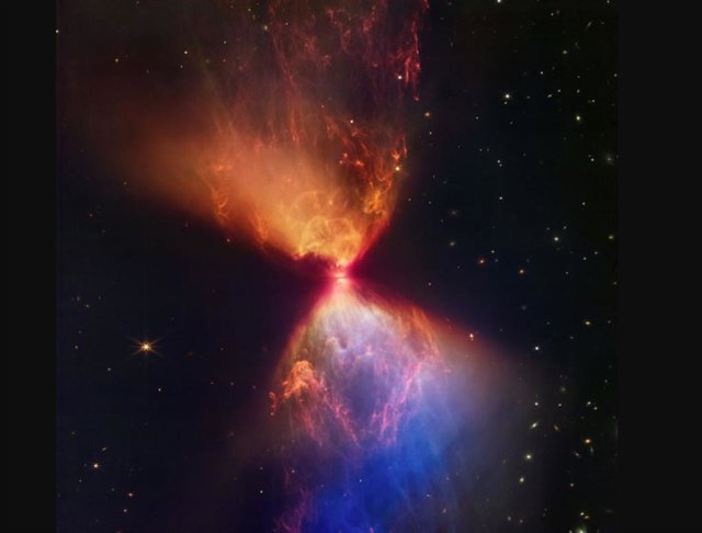 La protoestrella dentro de la nube oscura L1527, que se muestra en esta imagen de la cámara de infrarrojo cercano del telescopio espacial James Webb (NIRCam) de la NASA, está incrustada dentro de una nube de material que alimenta su crecimiento.