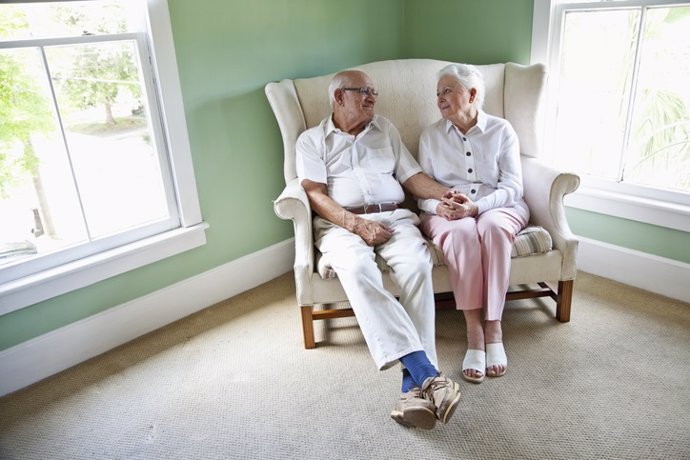 Archivo - Elderly couple sitting together on love seat