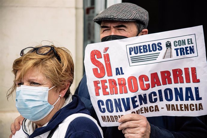 Archivo - Dos personas sostienen una pancarta que reza 'Pueblos con el tren, Sí al ferrocarril convencional', en una manifestación por el mantenimiento del tren convencional en la estación de tren de Aranjuez, a 9 de abril de 2022, en Aranjuez, Madrid (