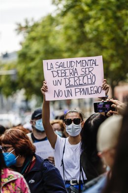 Archivo - Una mujer sostiene una pancarta donde se lee "La salud mental debería ser un derecho y no un privilegio", en una marcha con motivo del Día Mundial de la Salud Mental