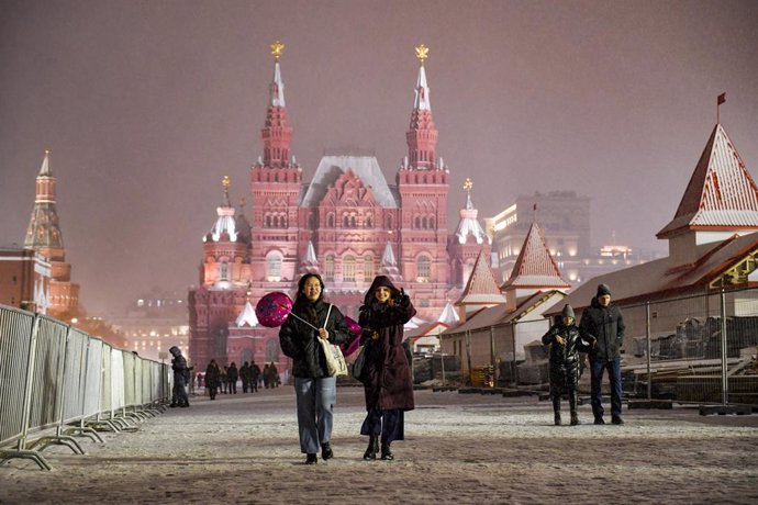 Un grupo de personas pasea sobre la nieve en la plaza Roja de Moscú