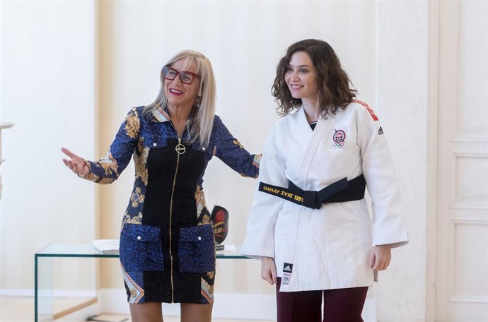 La presidenta de la Federación de Judo de Madrid, Meli Lorenzo (i), entrega a la presidenta de la Comunidad de Madrid, Isabel Díaz Ayuso (d), el cinturón negro honorífico concedido por la Federación Madrileña de Judo y Deportes Asociados en la Real Casa