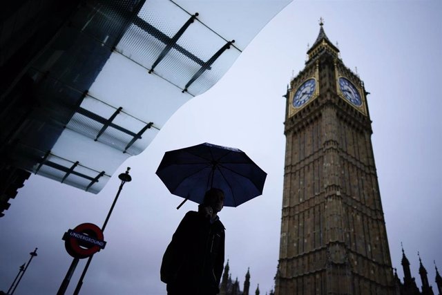 03 November 2022, United Kingdom, London: A commuter walks with an umbrella on a rainy morning in Westminster, London. Photo: Aaron Chown/PA Wire/dpa