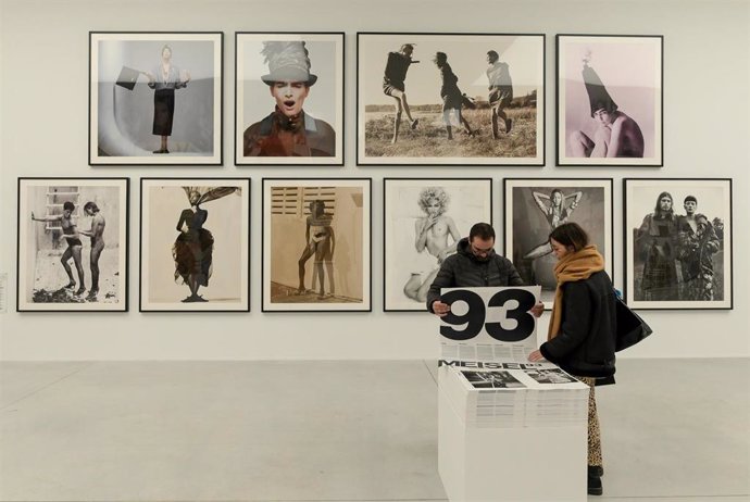Dúas persoas observan as obras na exposición ?Steven Meisel 1993 A Year in Photographs? no Peirao da Batería da Coruña, a 18 de novembro de 2022, na Coruña