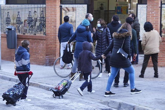Archivo - Unos niños cruzan un paso de peatones para entrar en el colegio tras las vacaciones de Navidad con la aplicación de las nuevas restricciones dependiente de cada comunidad autónoma, a 10 de enero de 2022 en Sevilla (Andalucía, España)