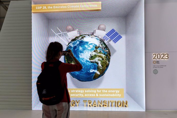 18 November 2022, Egypt, Sharm El-Sheikh: A woman takes a photograph in United Arab Emirates Pavilion which advertises next's year, 2023 conference in Dubai on the final day of the 2022 United Nations Climate Change Conference COP27. Photo: Dominika Zar