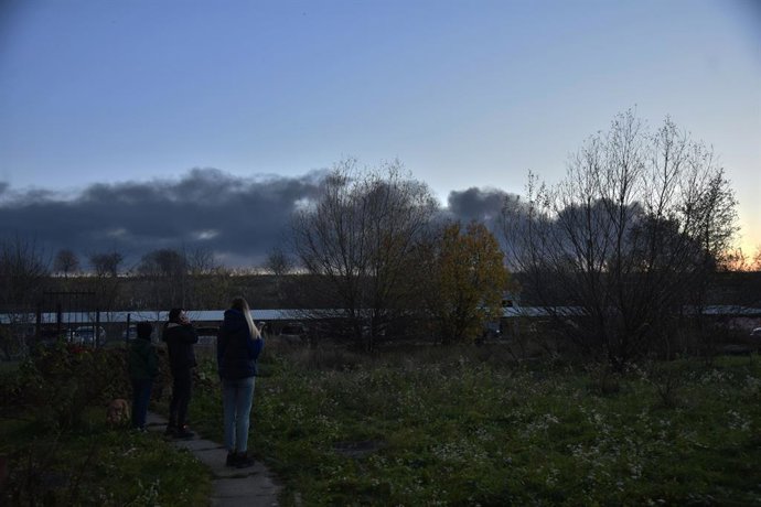 15 November 2022, Ukraine, Lviv: Residents stand in a meadow and watch clouds of smoke rising after a Russian missile attack on Lviv. Photo: Pavlo Palamarchuk/SOPA Images via ZUMA Press Wire/dpa
