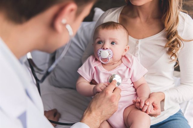 Archivo - Médico pediatra auscultando a un bebé.