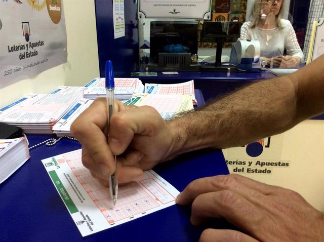 Archivo - Un hombre rellena un boleto de lotería, en una foto de archivo.
