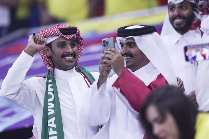 Dos aficionados de Qatar viendo a su selección en el partido contra Ecuador.