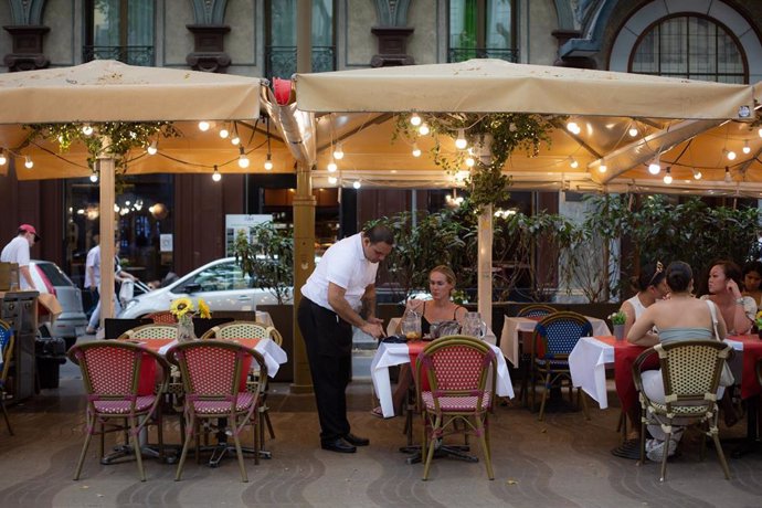 Archivo - Un camarero atendiendo una mesa en un restaurante de Barcelona