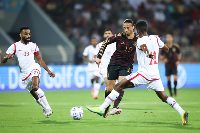 16 November 2022, Oman, Muscat: Germany's Leroy Sane (C) battles for the ball with Oman's Harib Al-Saadi (L) and Amjad al-Harthi during the International friendly soccer match between Oman and Germany at the Sultan Qabus Sports Center, in the Germany's 