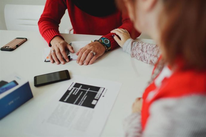 Una trabajadora de Cruz Roja acompaña a una mujer.