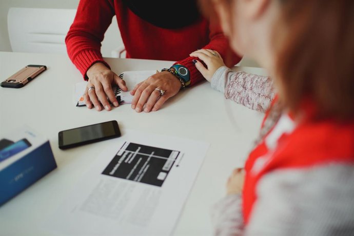 Una treballadora de Creu Roja acompanya una dona.