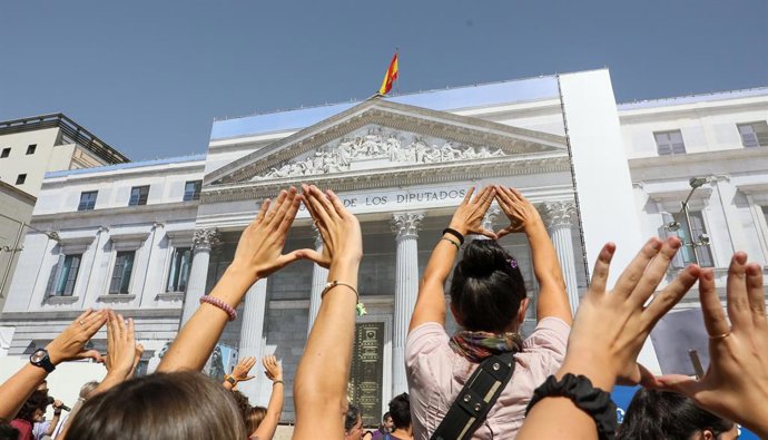 Archivo - Un grupo de mujeres del Movimiento Feminista de Madrid levantan los brazos construyendo un triángulo con las manos durante una acción reivindicativa frente al Congreso de los Diputados, a 5 de octubre de 2022, en Madrid (España). El Movimiento