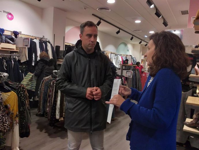 El concejal de Obras y Proyectos de Ciudad de Gijón, Olmo Ron, presidente de Emulsa, visita la tienda de Koopera, acompañado de la coordinadora general de la empresa de inserción Cáritas- Koopera Astur, en Asturias, Aída Rodríguez