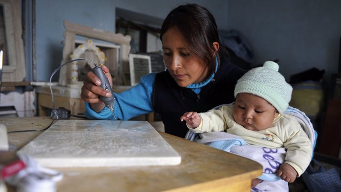 Una cuidadora junto a un bebé