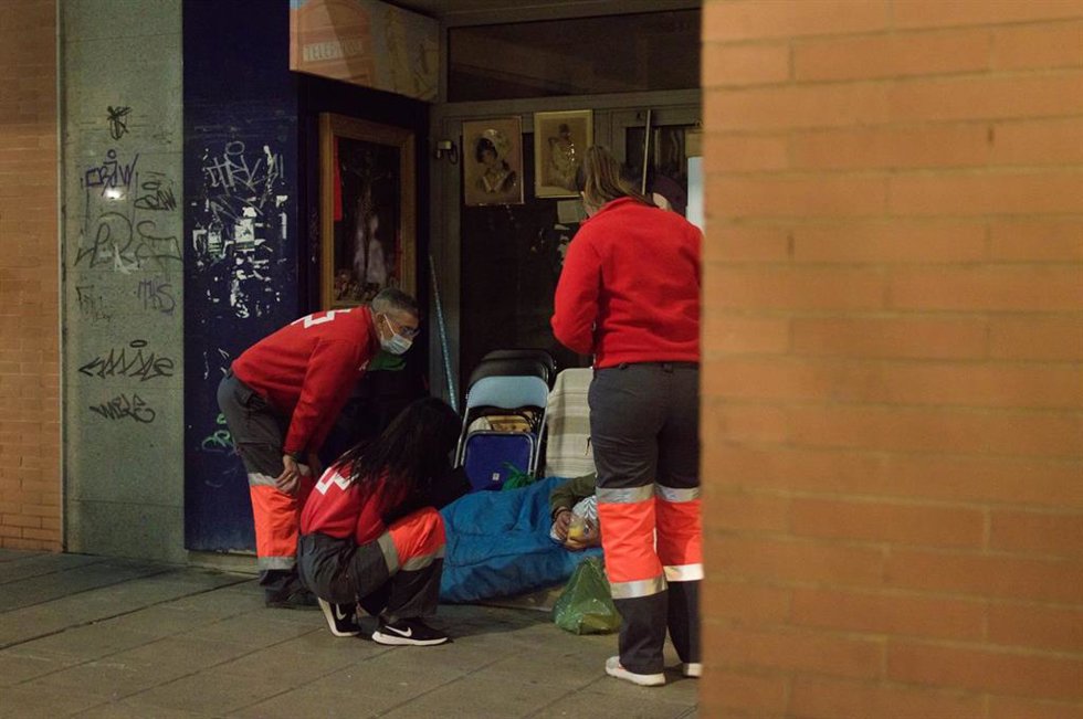 Voluntarios de Cruz Roja atienden a una persona sin hogar.