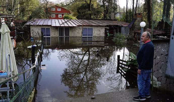 Un hombre observa una casa inundada por el desbordamiento del río Tea, a 23 de noviembre de 2022, en Ponteareas, Pontevedra, Galicia (España). Las inundaciones provocadas por la subida del río Tea está obligando a Protección Civil a desalojar a las pers