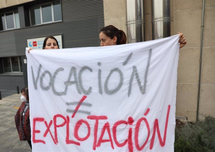 Dos mujeres sujetan una pancarta el la que se lee: 'Vocación no es igual a explotación' 