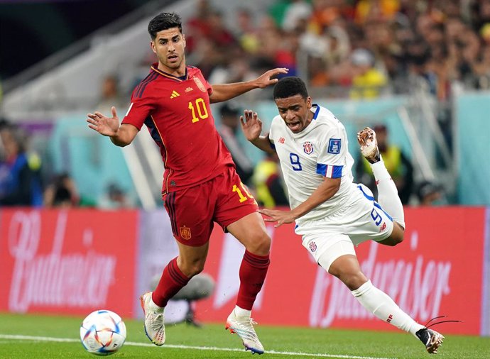 23 November 2022, Qatar, Doha: Spain's Marco Asensio (L) and Costa Rica's Jewison Bennette battle for the ball during the FIFA World Cup Qatar 2022 Group E soccer match between Spain and Costa Rica at the Al Thumama Stadium. Photo: Adam Davy/PA Wire/dpa