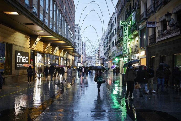 Archivo - Transeúntes caminan cerca de una zona comercial en la calle de Preciados, en Madrid (España).