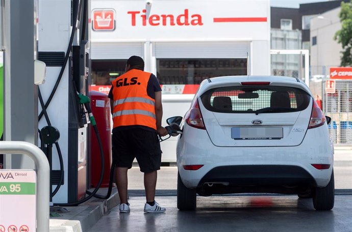 Archivo - Un pasajero reposta en una gasolinera.