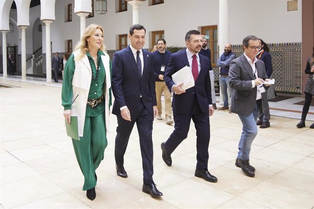 El presidente de la Junta de Andalucía, Juanma Moreno, este jueves junto al portavoz del PP, Toni Martín, y la consejera de Economía, Carolina España, en el Parlamento.