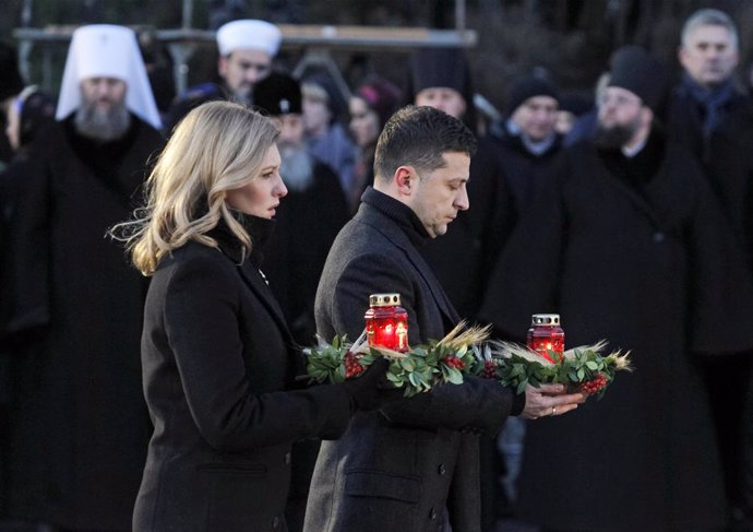 Archivo - 23 November 2019, Ukraine, Kiev: Ukrainian President Volodymyr Zelensky (R) and his wife Olena (L) carry flowers during a memorial ceremony near a monument to the victims of the Great Famine. Ukrainians light candles to mark a day of memory fo