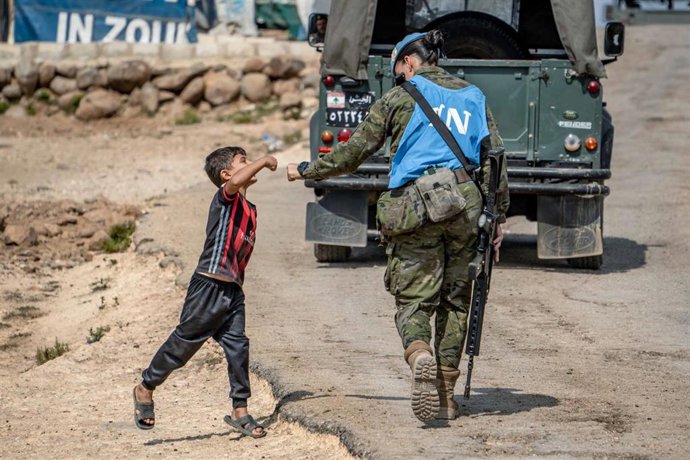 Archivo - Una militar de la Brigada de Córdoba en Líbano saluda a un niño durante una patrulla.