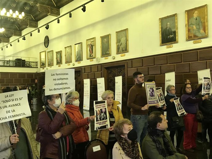 Un grupo de mujeres piden durante la celebración del acto institucional del 25N en el salón de plenos del Ayuntamiento de Zaragoza, la dimisión de la consejera municipal de Economía, Innovación y Empleo del consistorio, Carmen Herrarte